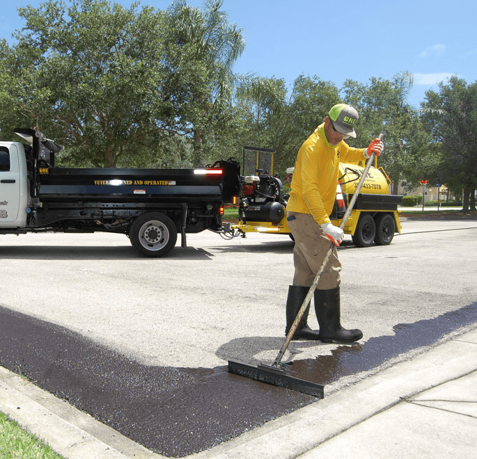 Worker resurfacing the road